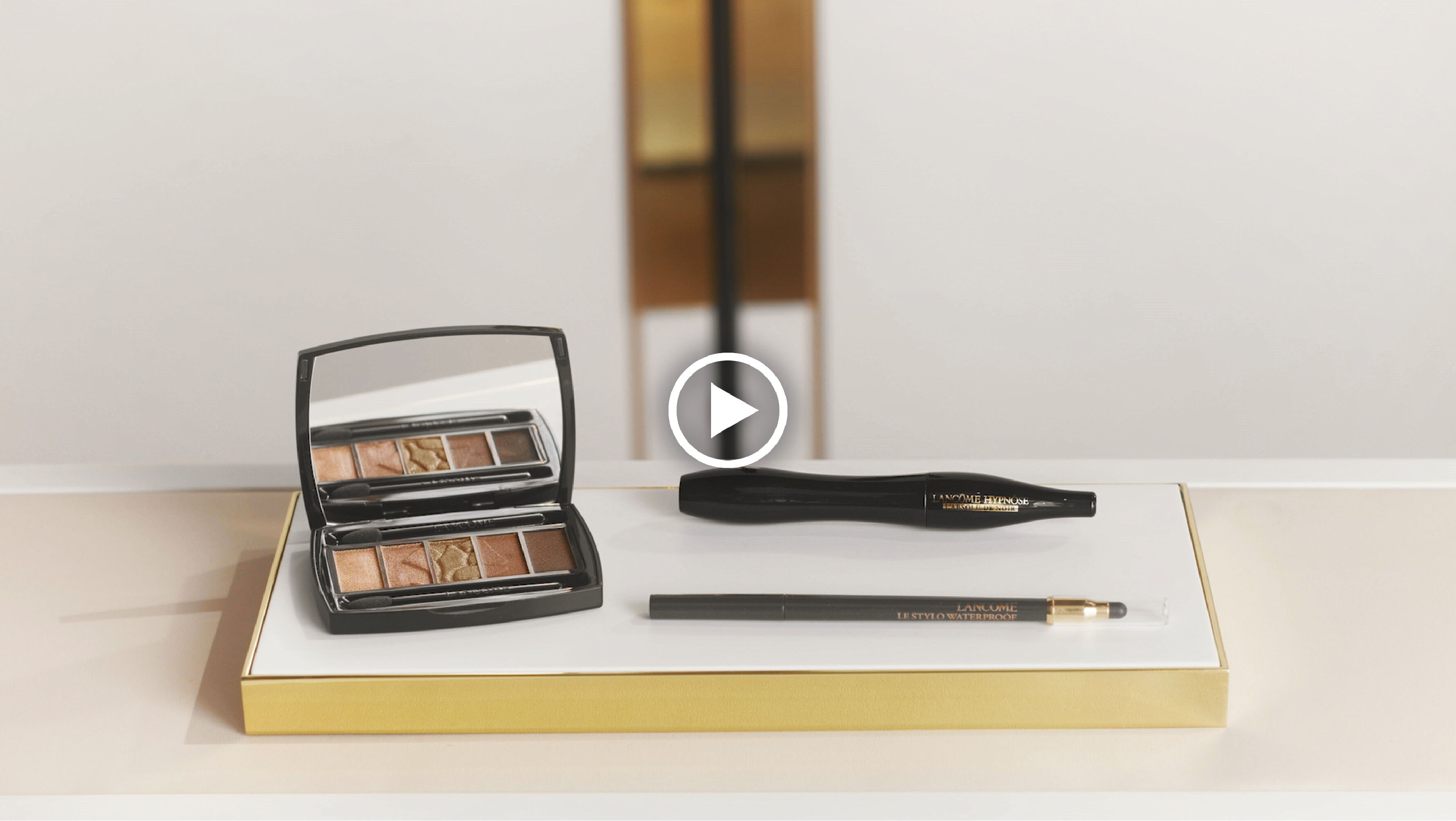 Zwart make-upset met oogschaduwpalet, eyeliner en potlood op een elegante ondergrond met gouden rand.