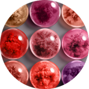 Colorful, glossy spheres in shades of red, pink, and gold arranged in a circular pattern against a gray background.