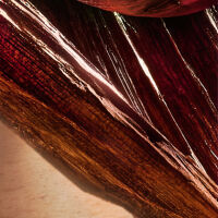 Kleurrijke close-up van textuur van een bloemblad met glanzende en gemarmerde oppervlakken.