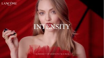 A model in a red dress holds a lipstick while looking directly at the camera, with the word "INTENSITY" prominently displayed in large font above her.