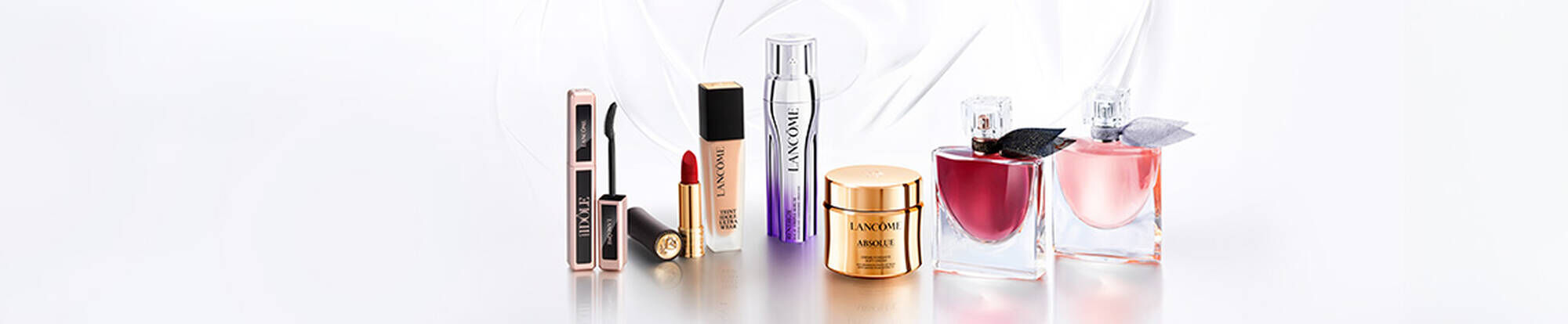 Three Lancome skincare products displayed on a gradient background, featuring sleek, modern packaging.