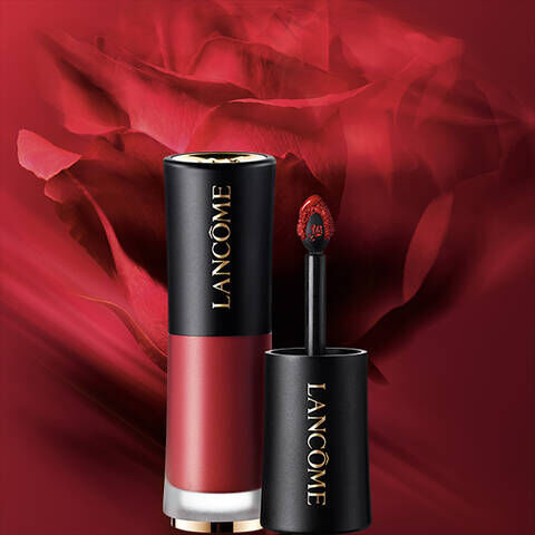 Alt-tekst: Een rode lipstick van Lancome met een applicator, naast een vervaagde afbeelding van een rode roos op de achtergrond.