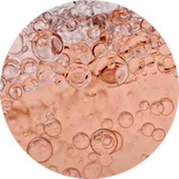 Kleine belletjes stijgen op in een rose vloeistof, met een zachte, glanzende achtergrond.