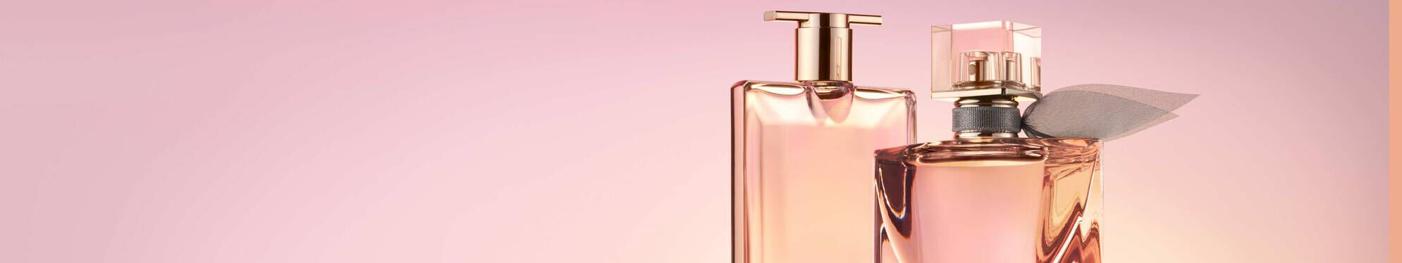 Two elegant perfume bottles are displayed against a soft pink background. One bottle is tall and sleek, while the other is shorter with a decorative cap and ribbon.