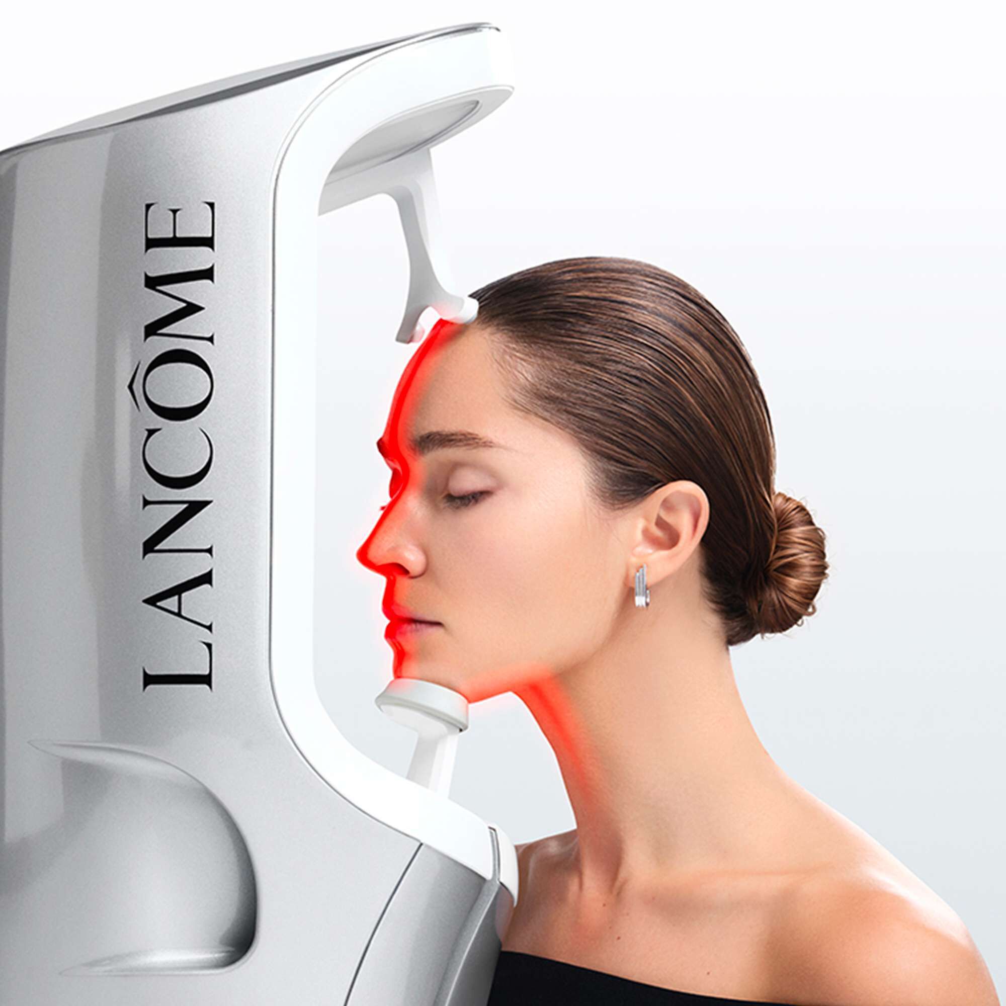 Alt-tekst: Een Lancome e-Skin Expert apparaat naast een smartphone die een huidanalyse toont, met drie huidverzorgingsproducten op de voorgrond.